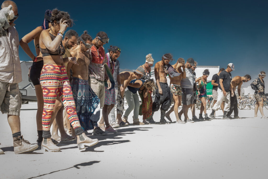 A long line of people, walking together looking for trash on the ground