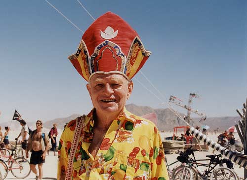 Person dressed as a pope in Black Rock City, with a red hat. 