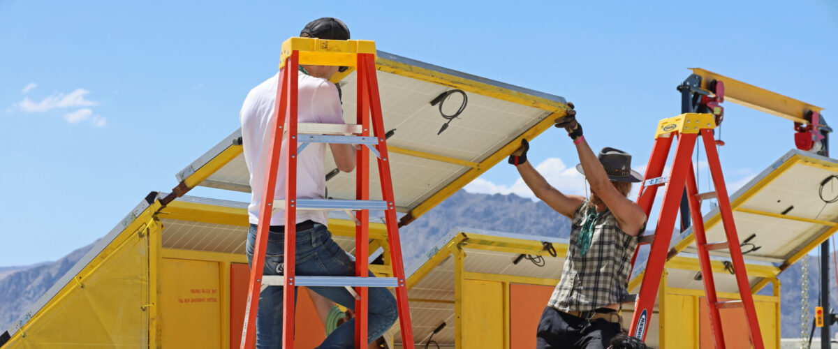 Artist Jered Ficklin and the Solarians install The Solar Library. A team of Burners installing a large solar panel.