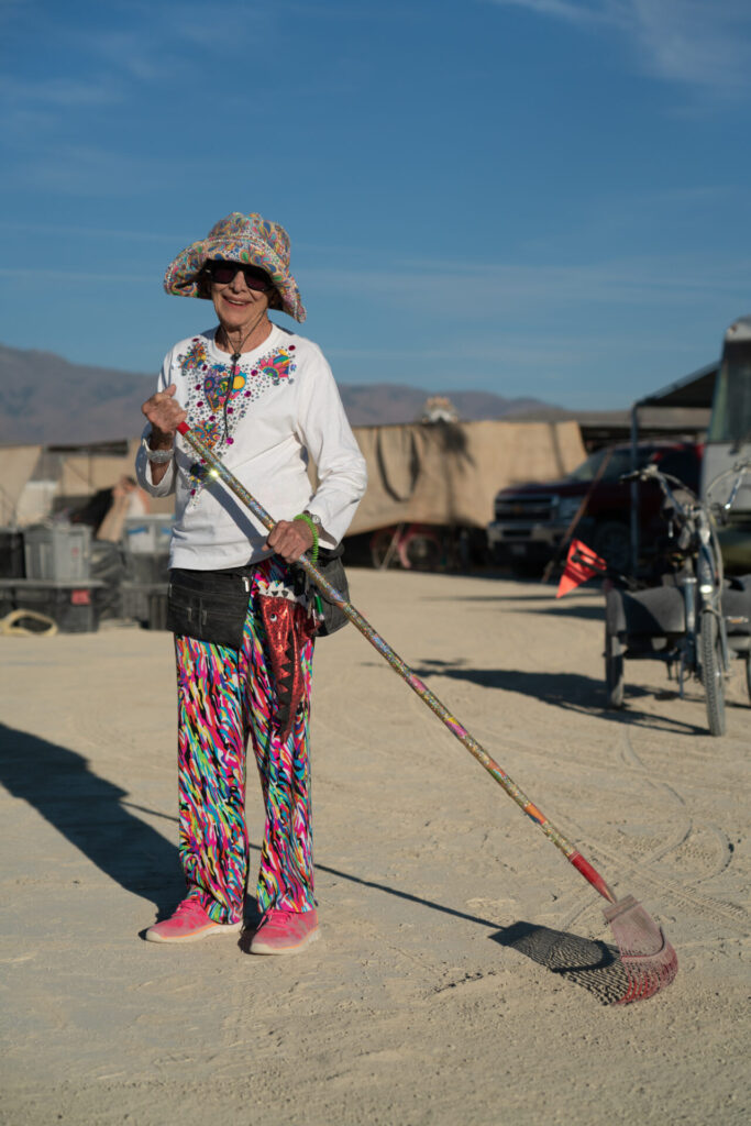 A white woman with a rake in Black Rock City