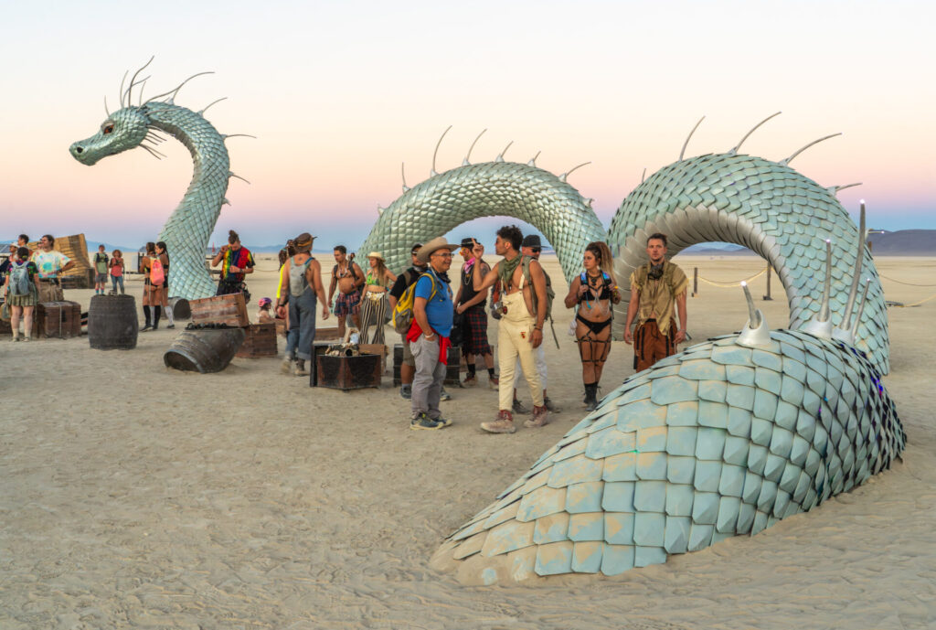 A sea dragon head and curves of it's body extend out of the ground. 