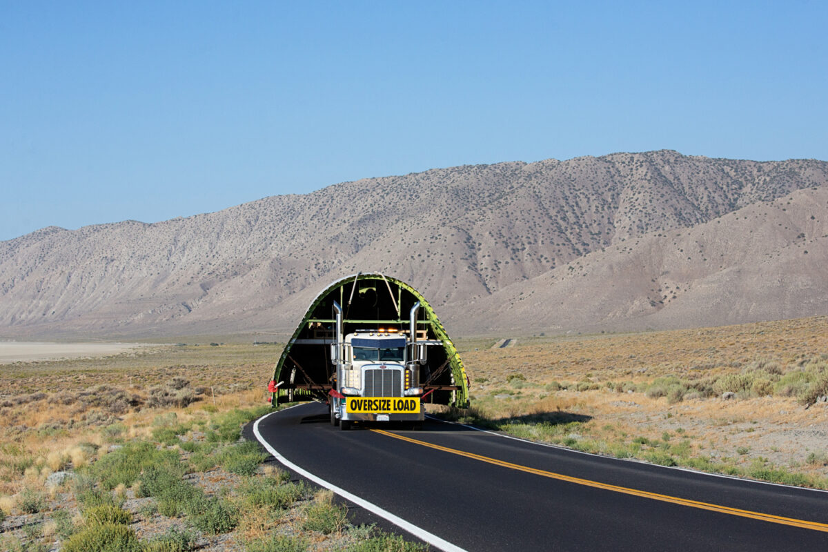 Oversize load on a truck taking up both lanes of a two lane road