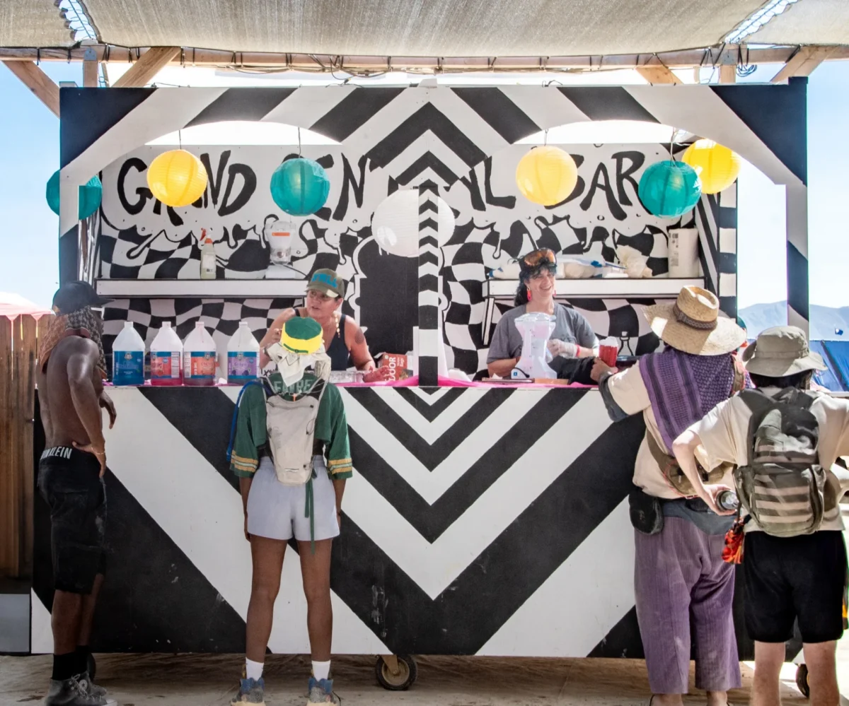 Participants stand at a counter where two people are serving snowcones.