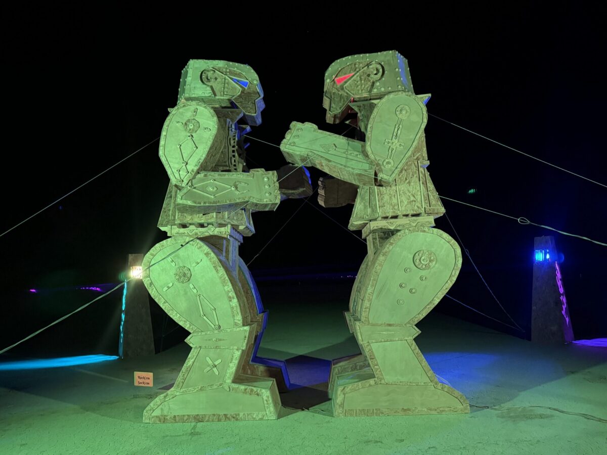 Two wooden figures evocative of the rock-em-sock-em-robots game