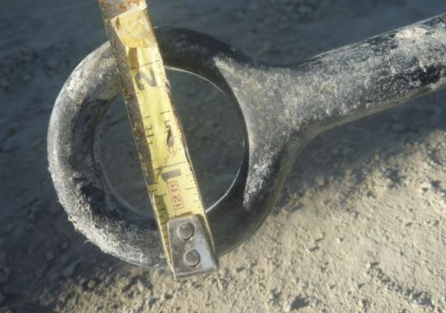 Measuring tape shows outer diameter of ring at the top of the anchor is 2.5 inches, inner 1.5 inches.
