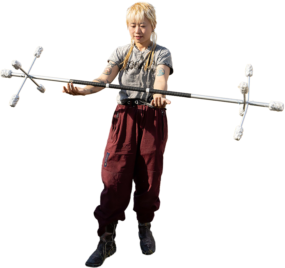 A person practicing to spin fire poi with a Dragon Staff.