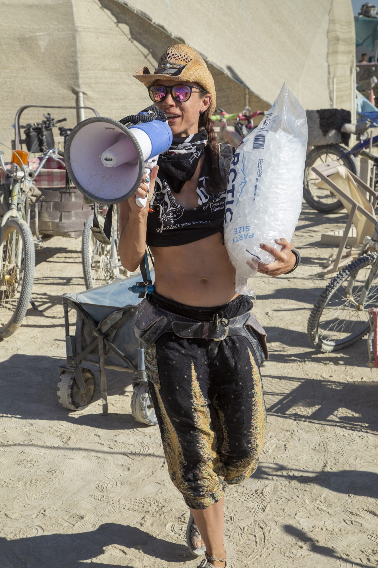 A participant with megaphone carries a bag of ice
